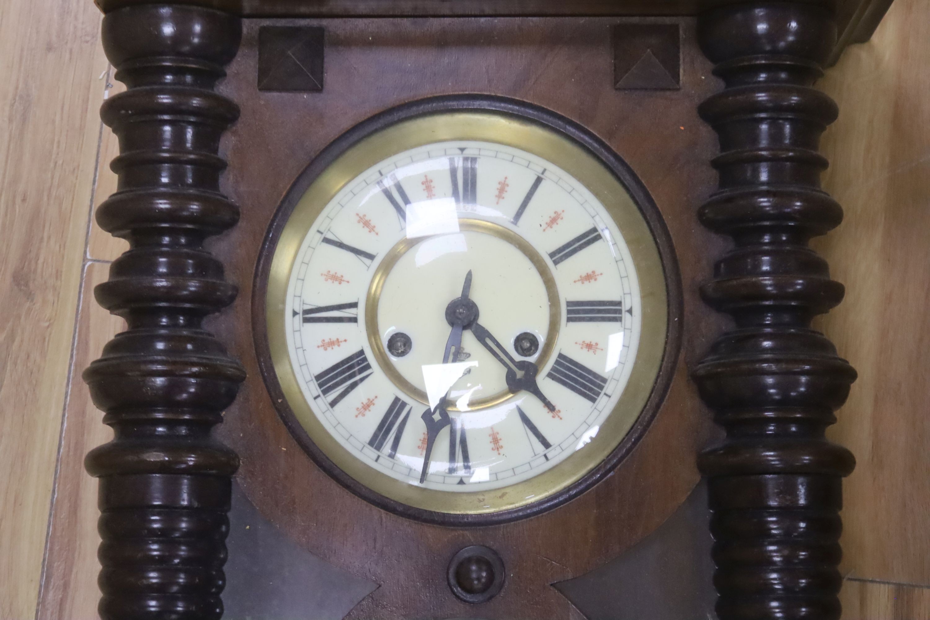 A 19th century Continental wall clock, in architectural walnut case, with key and pendulum, 95cm